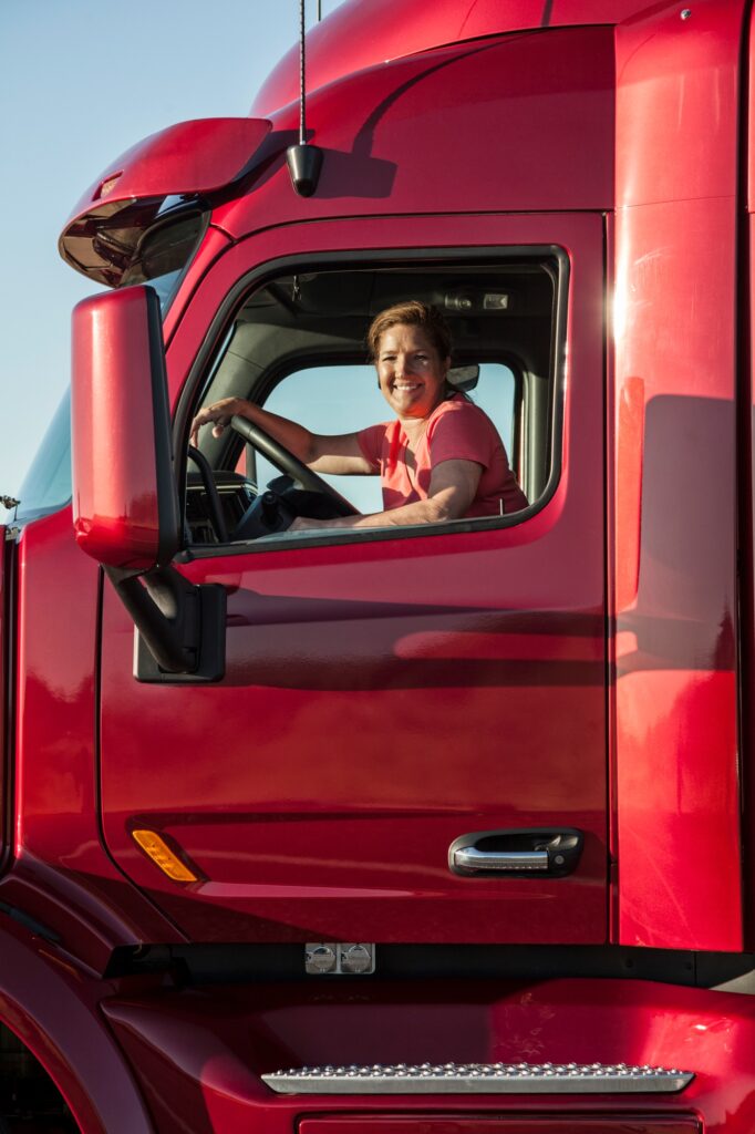 Portrait of a Caucasian woman driver and her commercial truck.